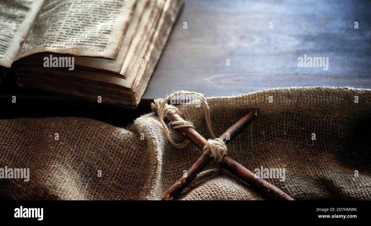 Religious old book on a wooden table. A religious cross tied with a