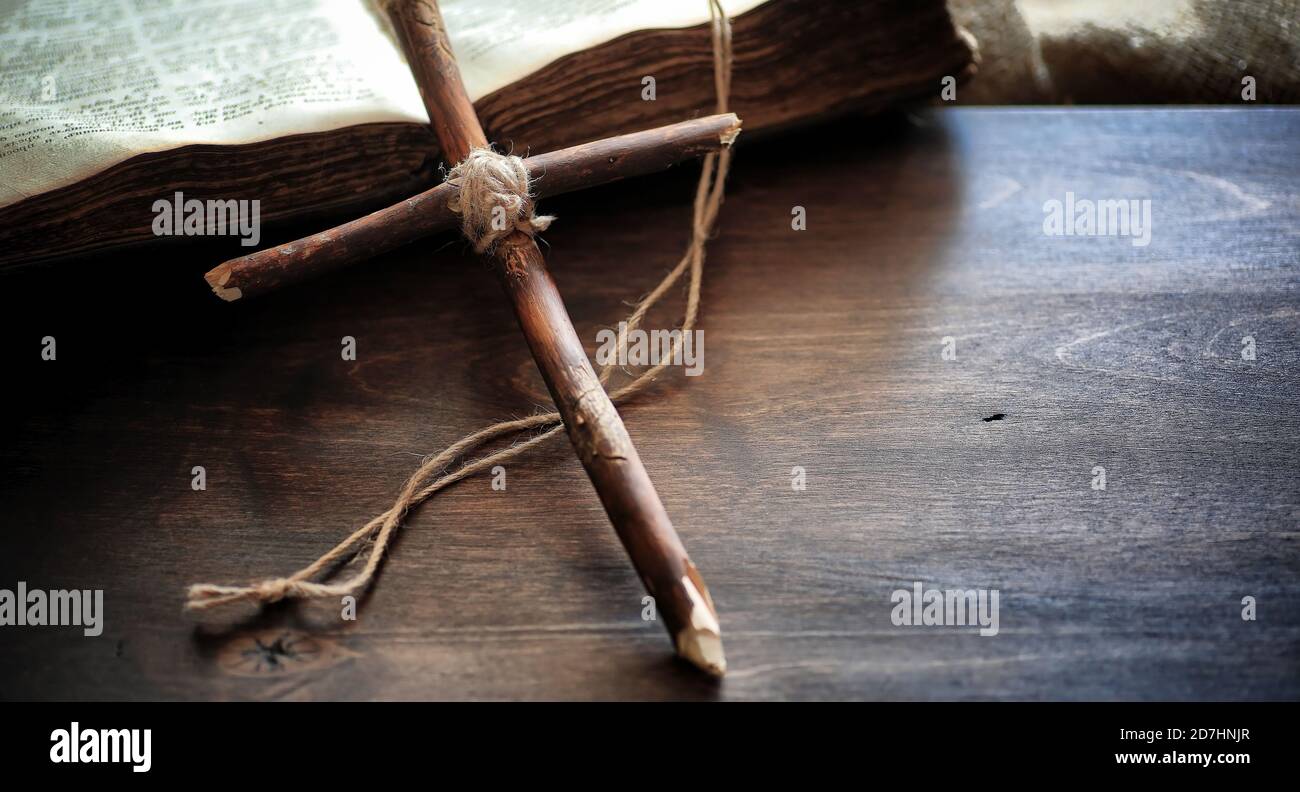 Religious old book on a wooden table. A religious cross tied with a