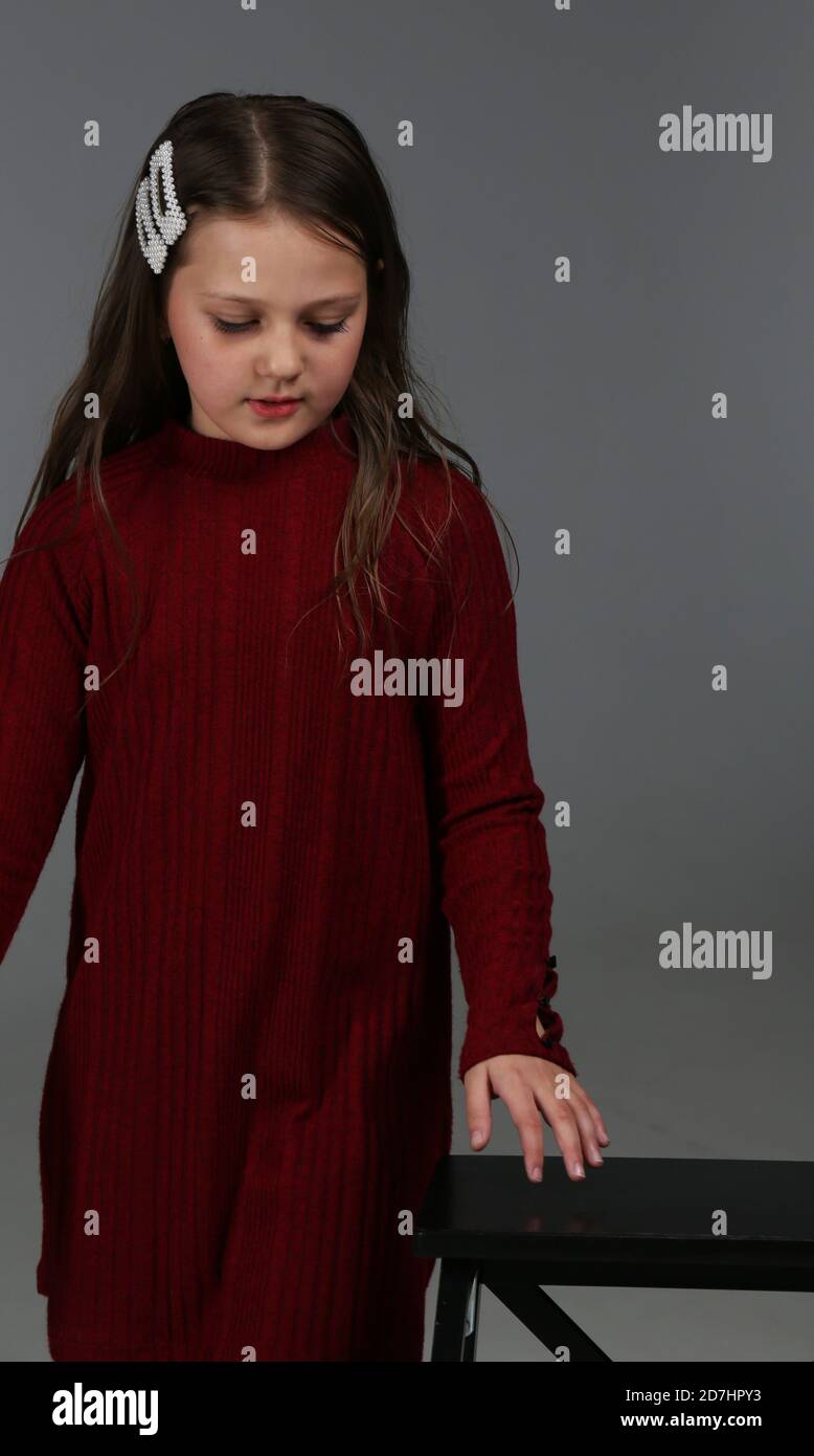 beautiful little girl with long brown hair and big brown eyes in a red dress. Yaroslavl Russia 10.10.2019 Stock Photo
