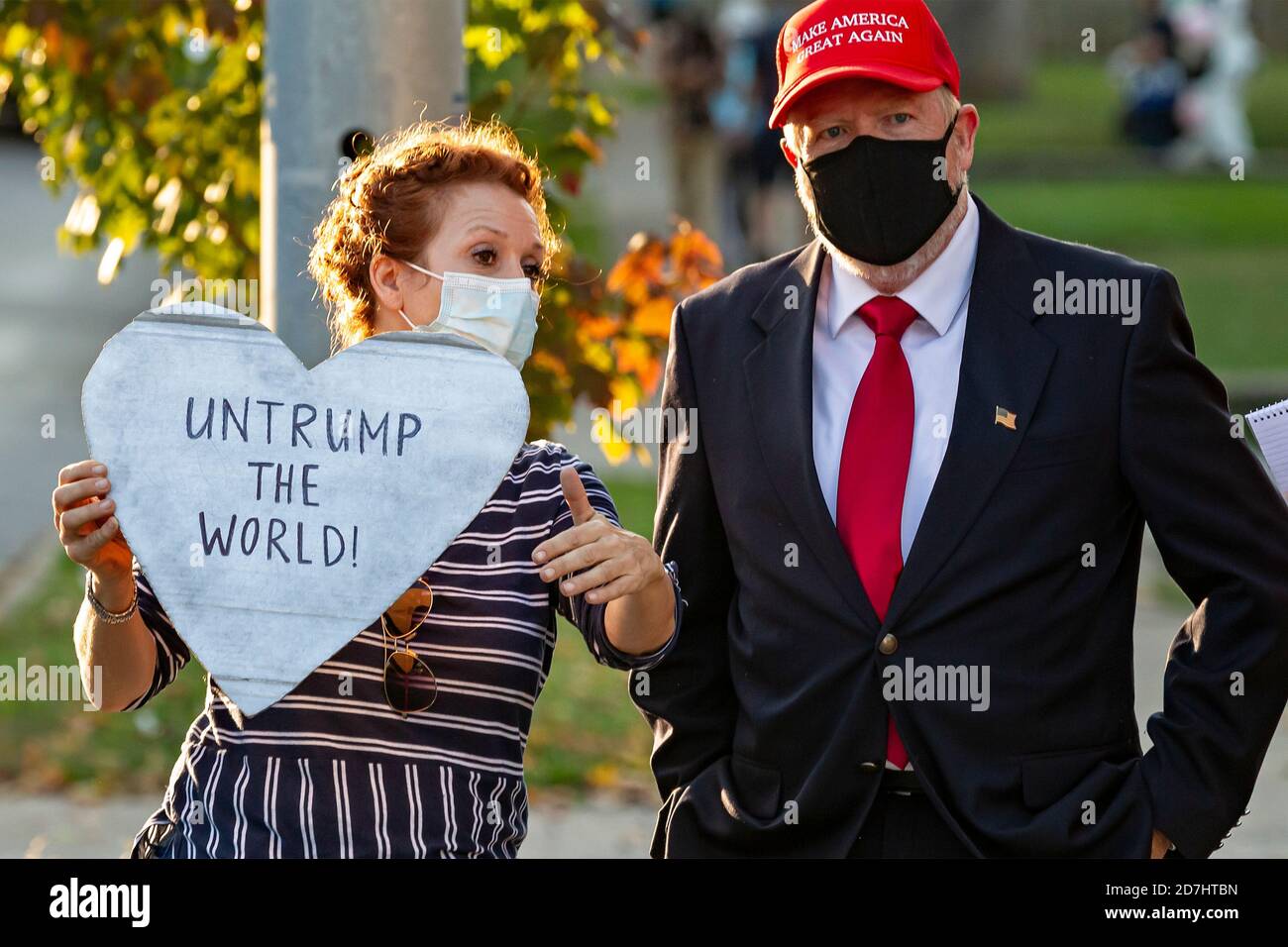 Nashville, Tennessee, USA, 22 October 2020 Security was tight on the Belmont University campus on the eve of the final presidential debate between President Donald Trump and former Vice President Joe Biden. Supporters for each candidate display signs and banners. A Biden supporter with a sign reading  “UnTrump the World” talks to a Trump supporter who is wearing a MAGA cap. Stock Photo