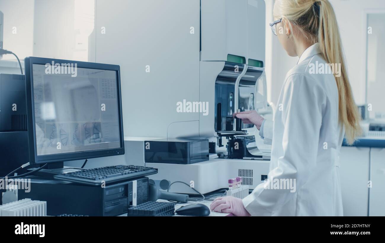Female Research Scientist Working with Medical Analyzing Machine for