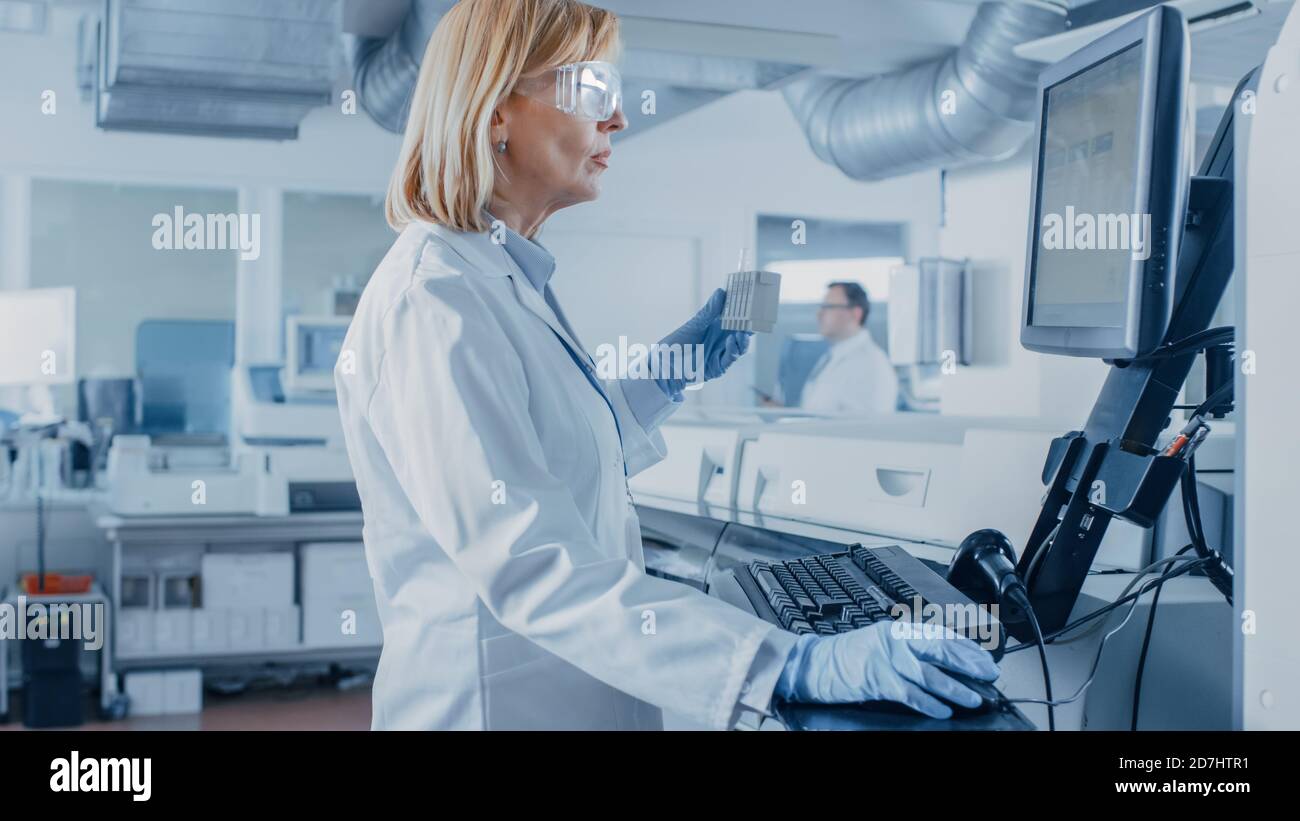 In Laboratory Female Scientist Analyzes Test Tube Data with Blood ...