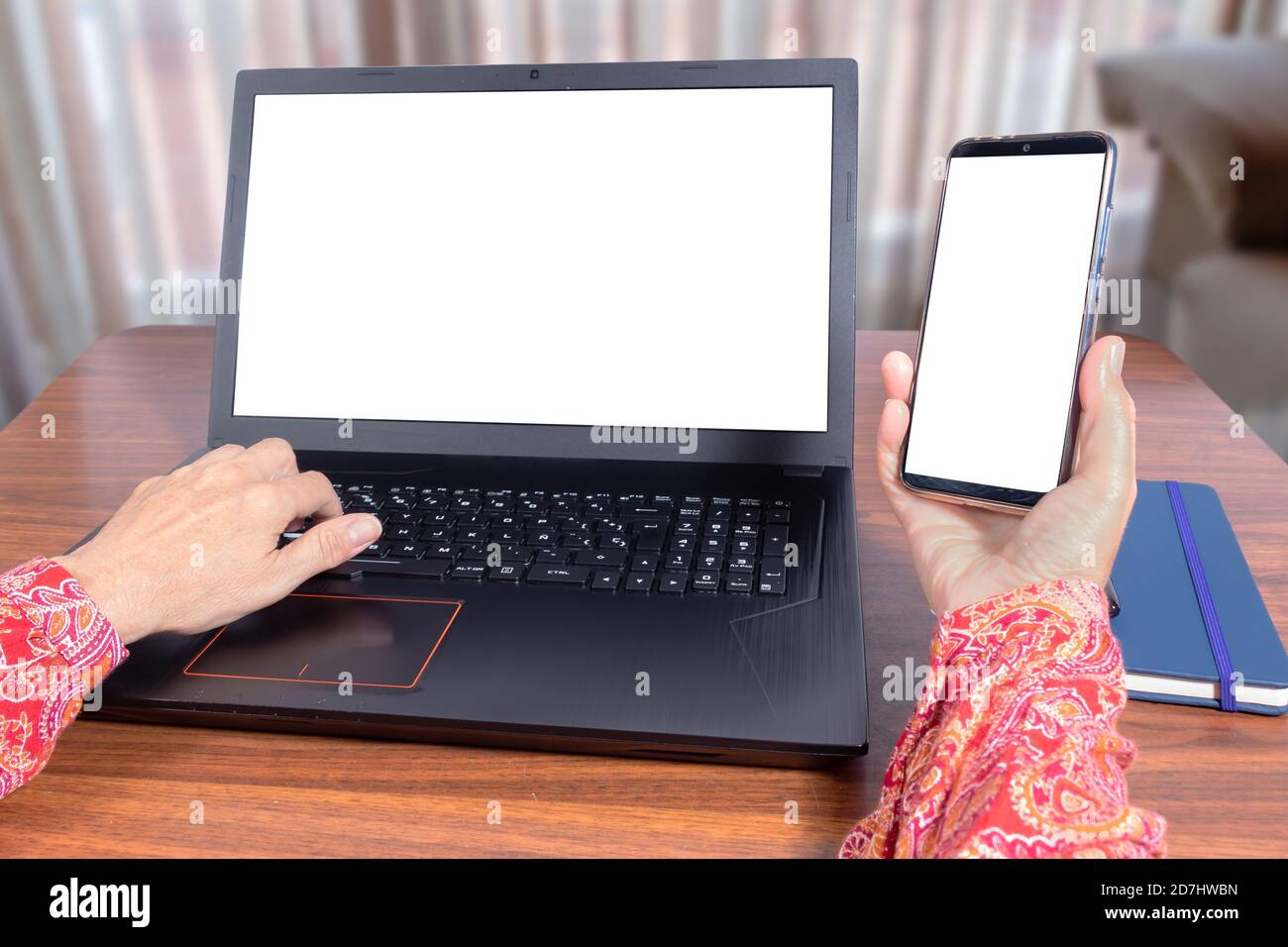 Woman Using laptop and mobile phone at home as teleworking concept Stock Photo