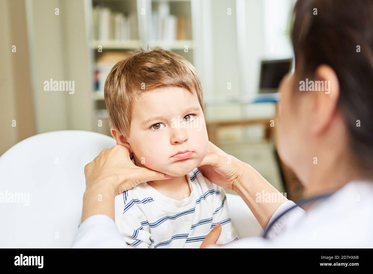 Pediatrician palpates lymph nodes and tonsils in a child with a sore