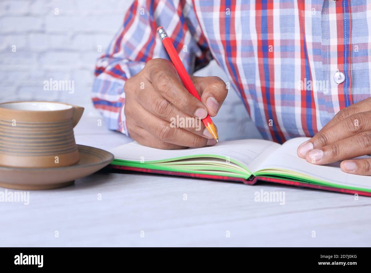 Close up of man hand writing on notepad Stock Photo - Alamy
