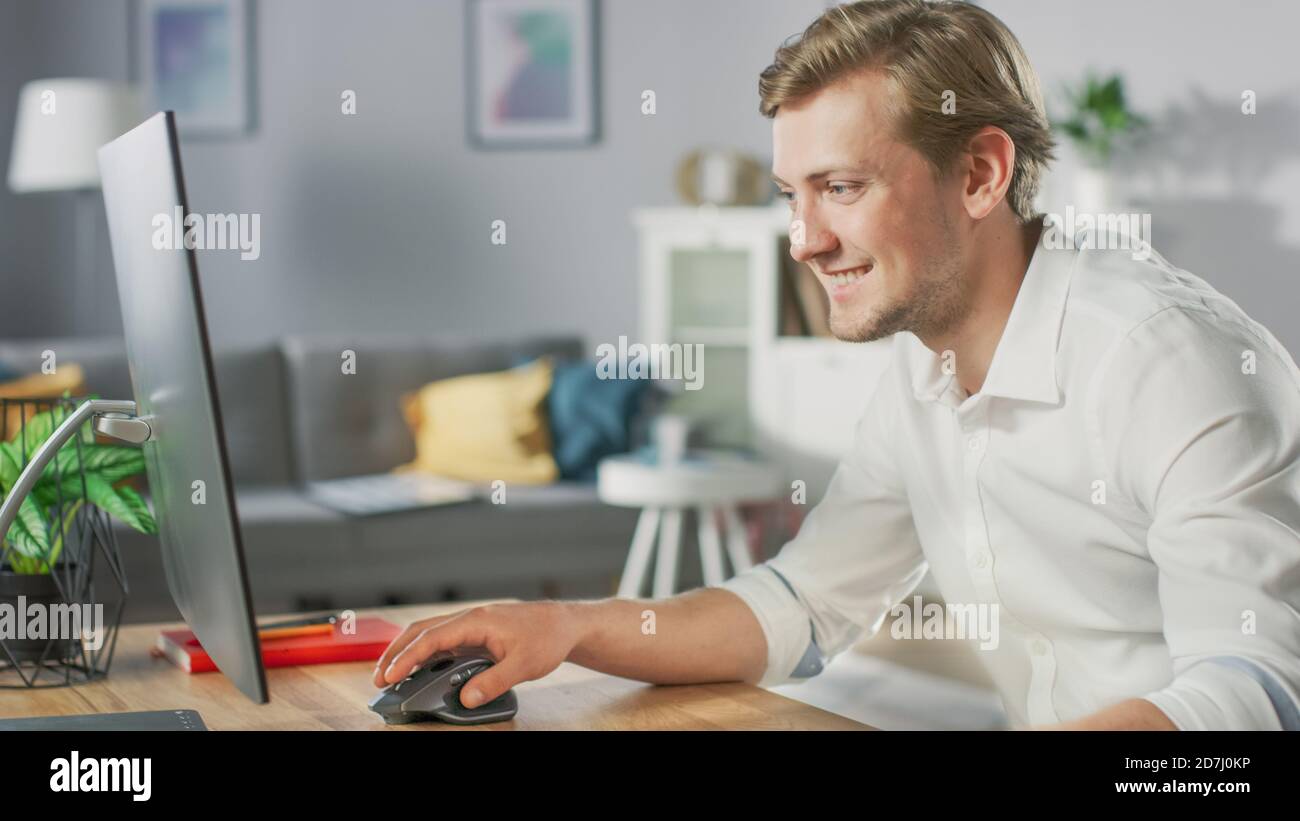 Portrait of the Handsome Mobile Application Designer Working On Personal Computer at His Desk. Stock Photo