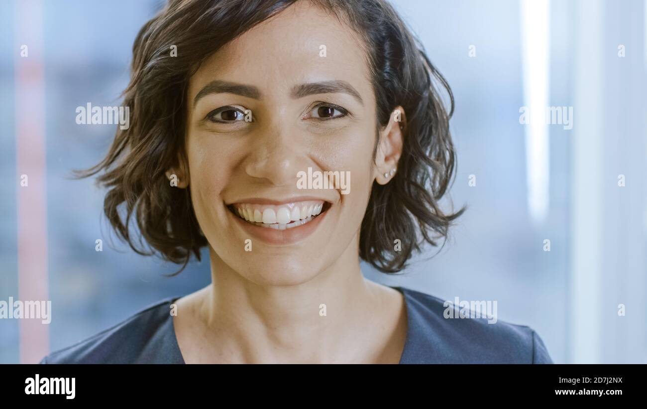 Beautiful hispanic business woman smiling over a white background ...