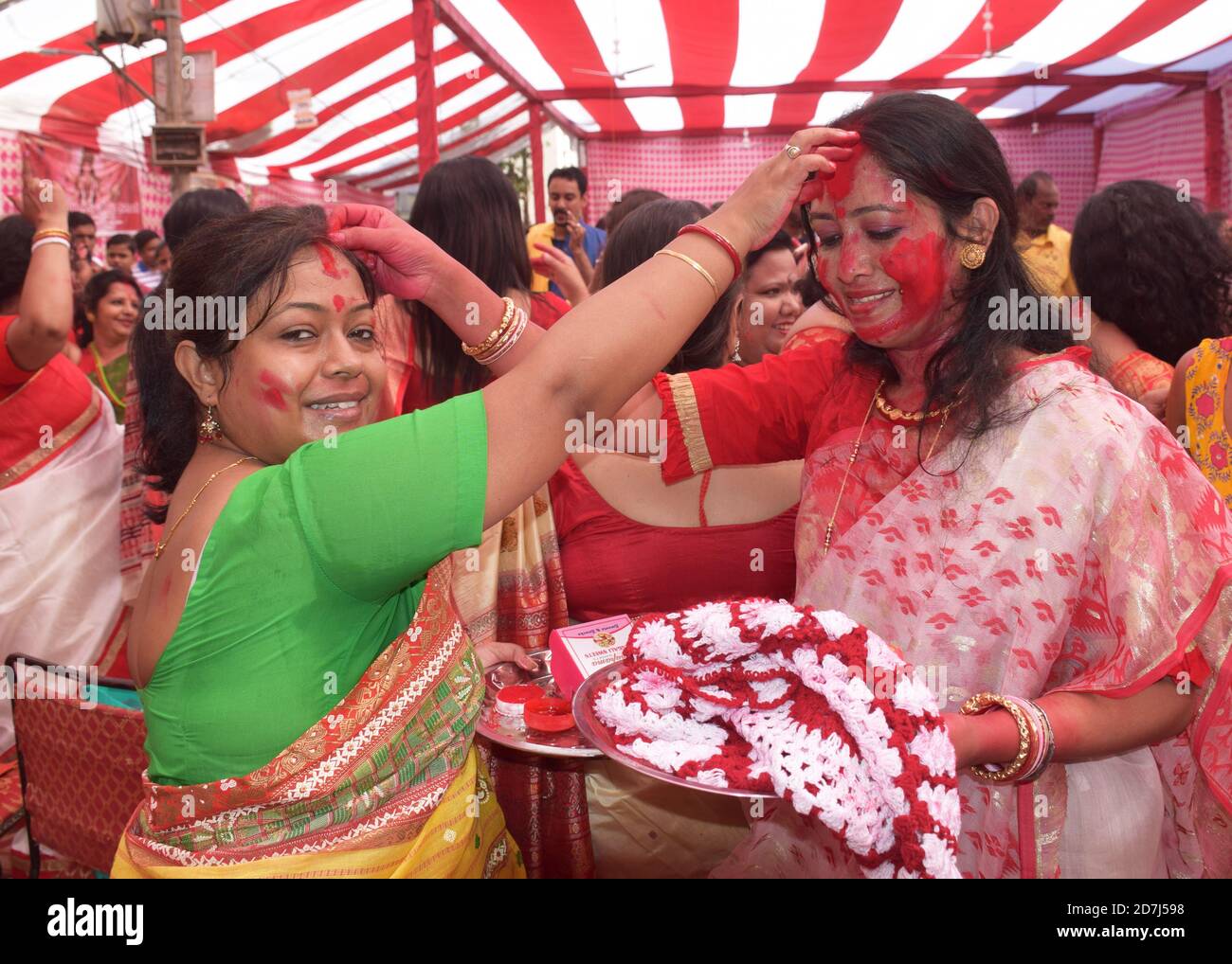 Indian Bengali women playing or applying Vermilion to each other during Durga Puja a ritual known as Sindoor Khela or sindur khela in Bengali Language Stock Photo