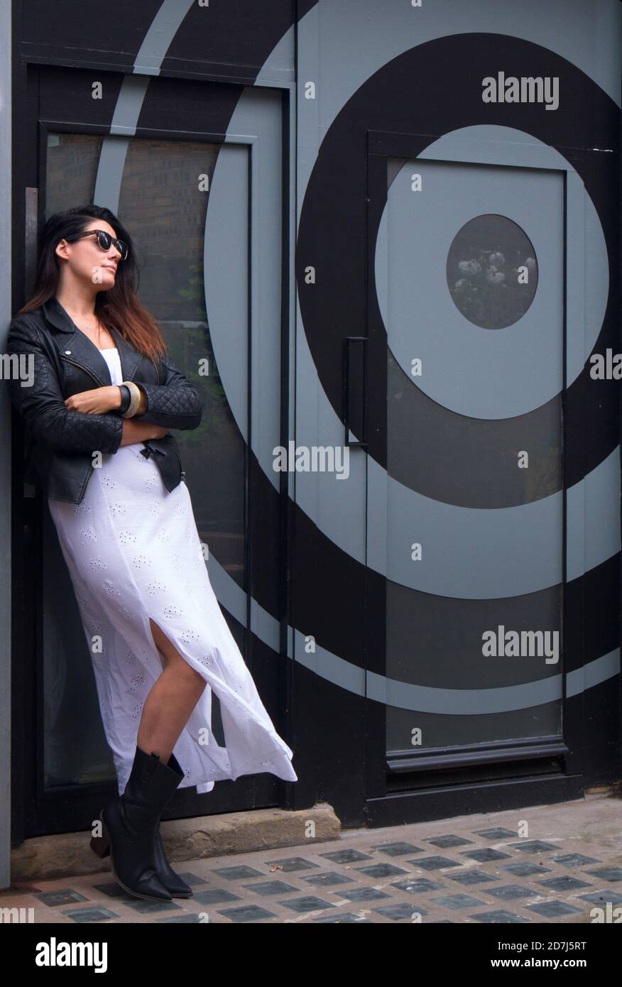 Stylish woman standing in front of circular graphic design Stock Photo