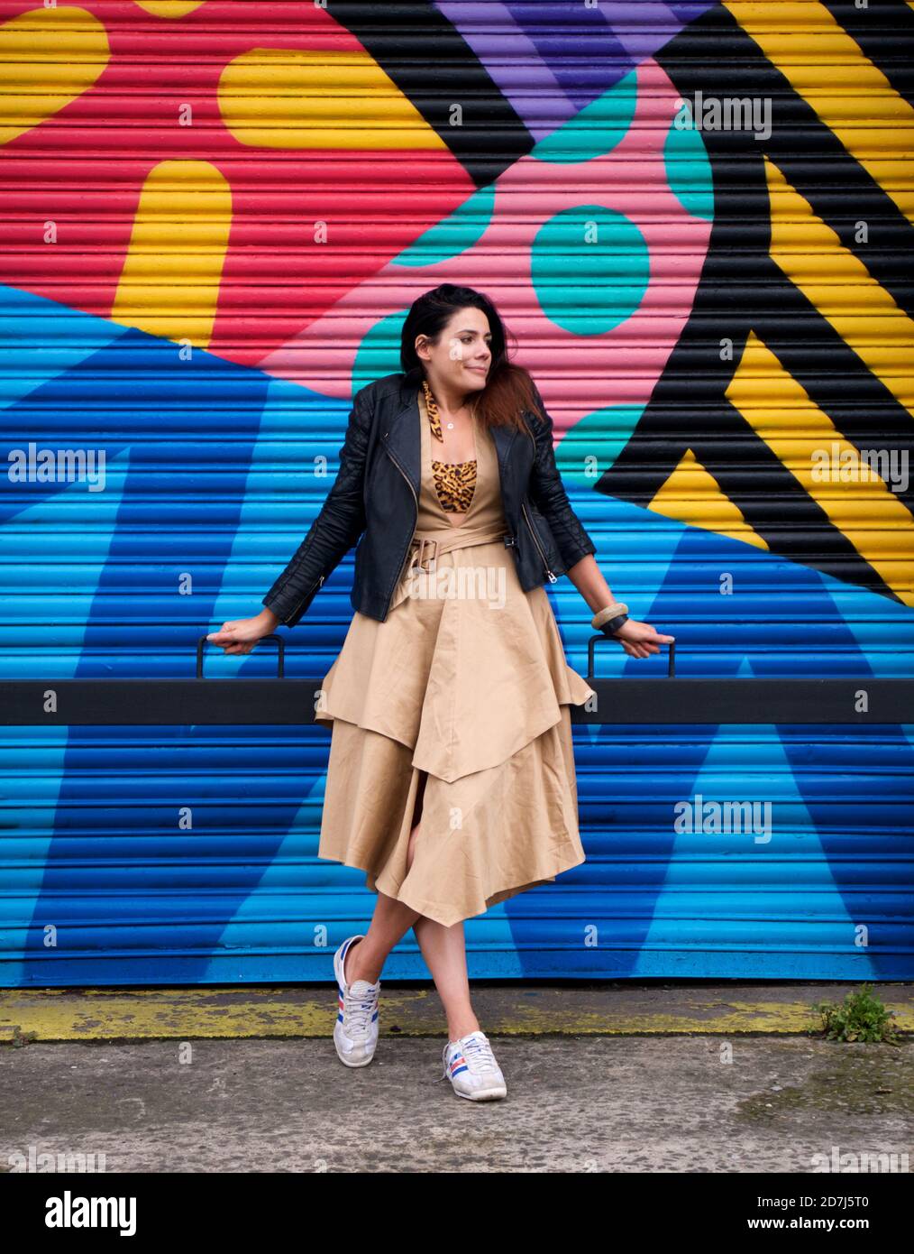 stylish woman standing in front of colourful mural Stock Photo