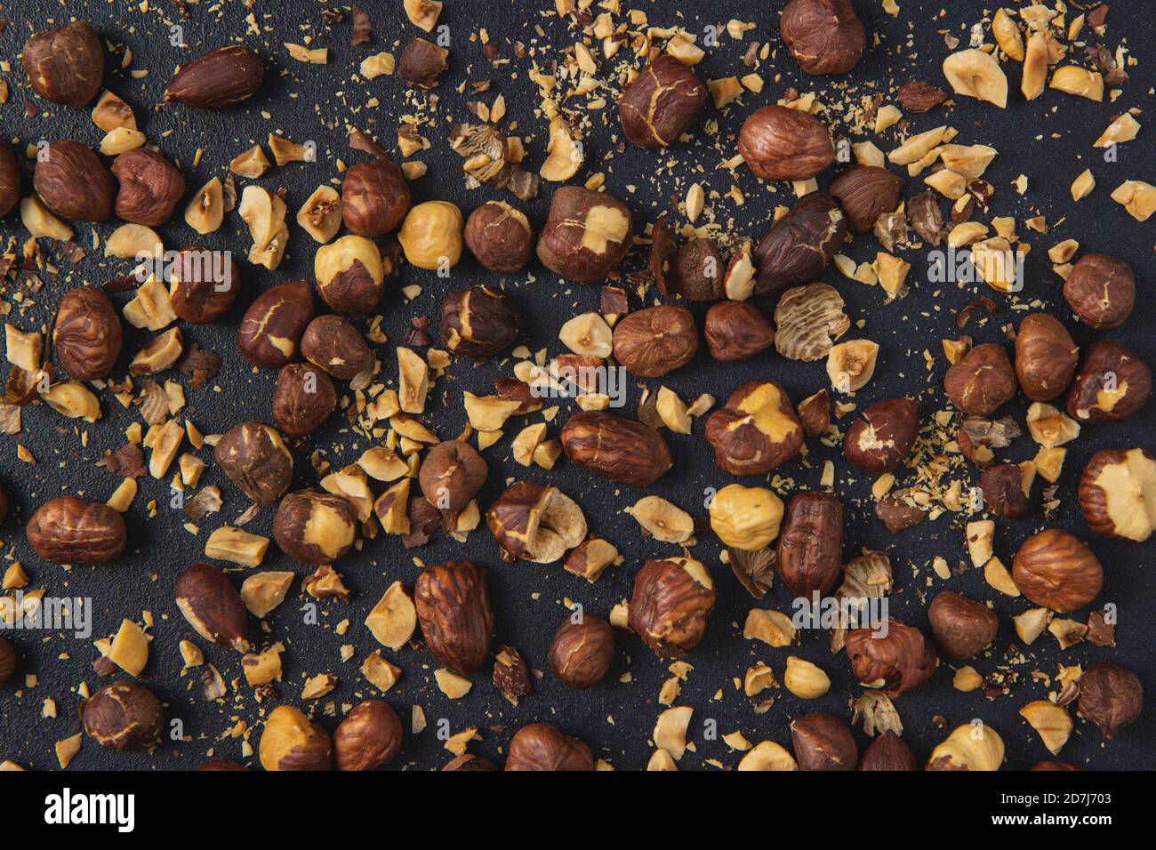 Background image of roasted hazelnuts isolated on the dark background. Roasted Hazelnuts. Stock Photo