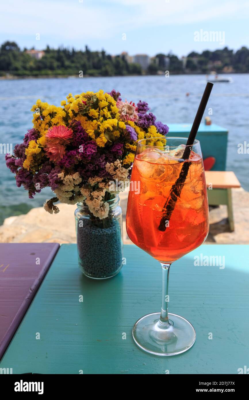 Close up of a cocktail with flowers and sea view on a sunny day, Rovinj, Croatia Stock Photo
