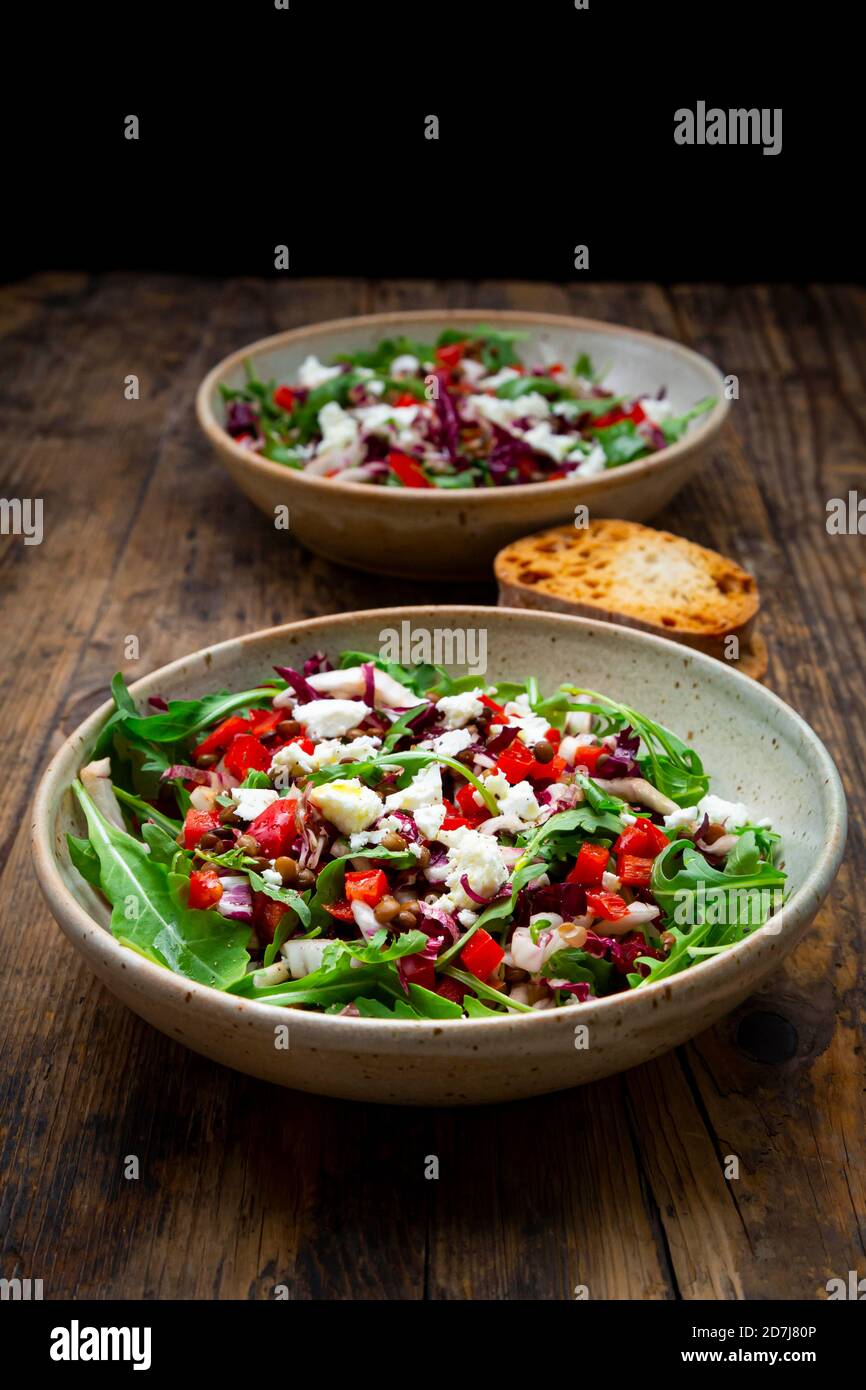 Two bowls of vegetable salad with lentils, arugula, red bell pepper, feta cheese and radicchio Stock Photo