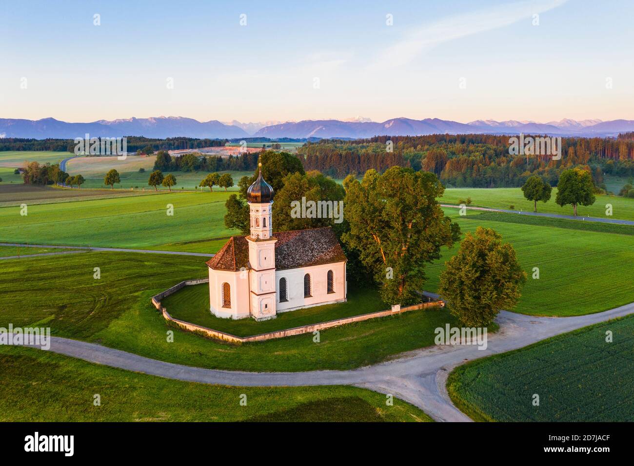 Germany, Bavaria, Etting, Drone view of Saint Andrew church surrounded by green fields at dawn Stock Photo