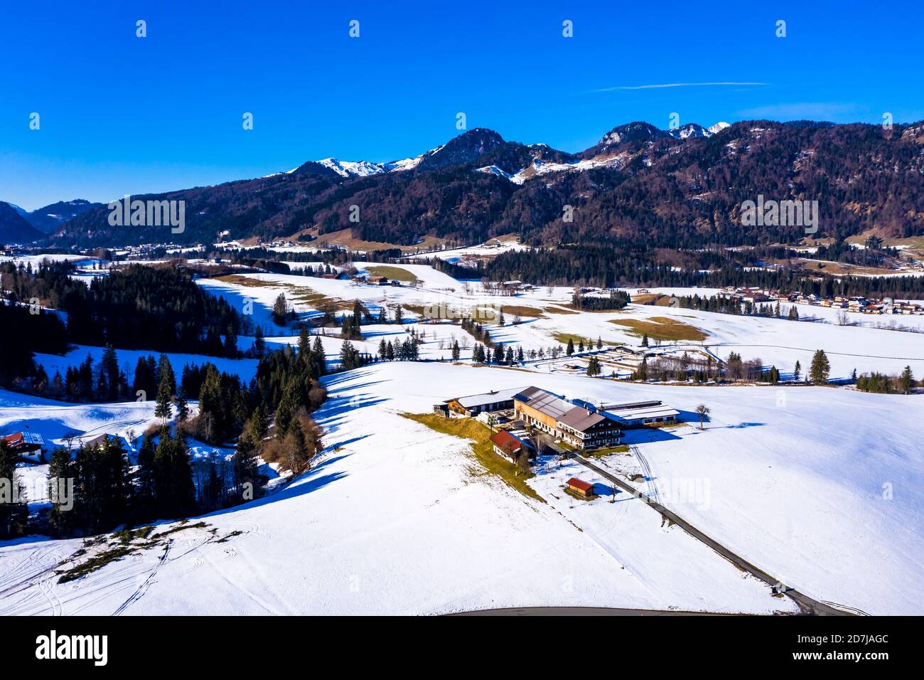 Austria, Tyrol, Kossen, Helicopter view of mountain village in snow-covered Leukental valley Stock Photo