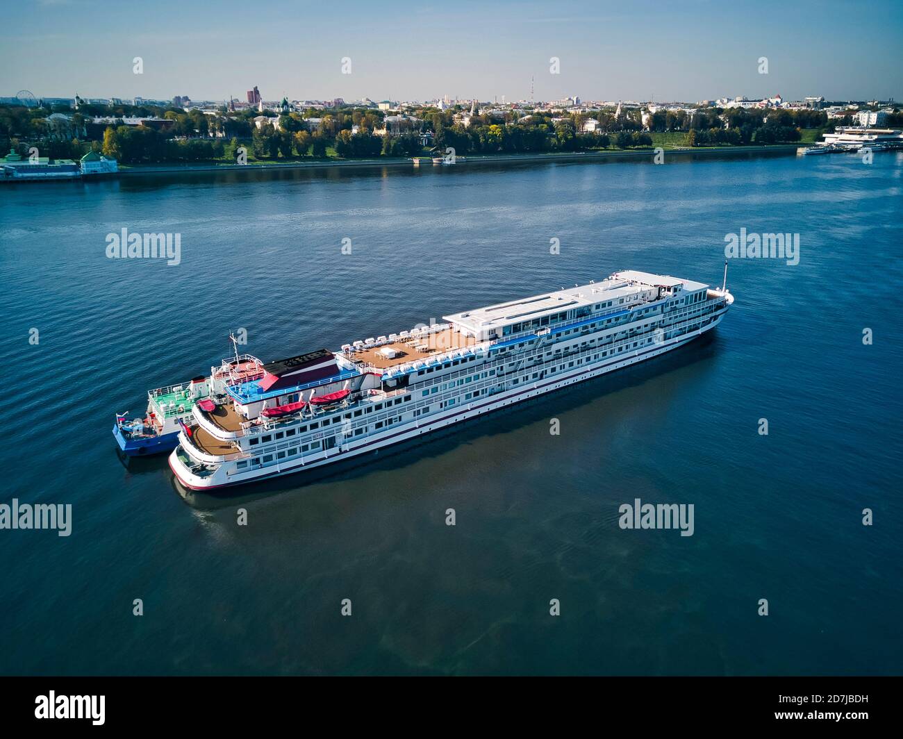 Aerial view of recreational boat being refueled from barge on Volga River near city during sunny day Stock Photo