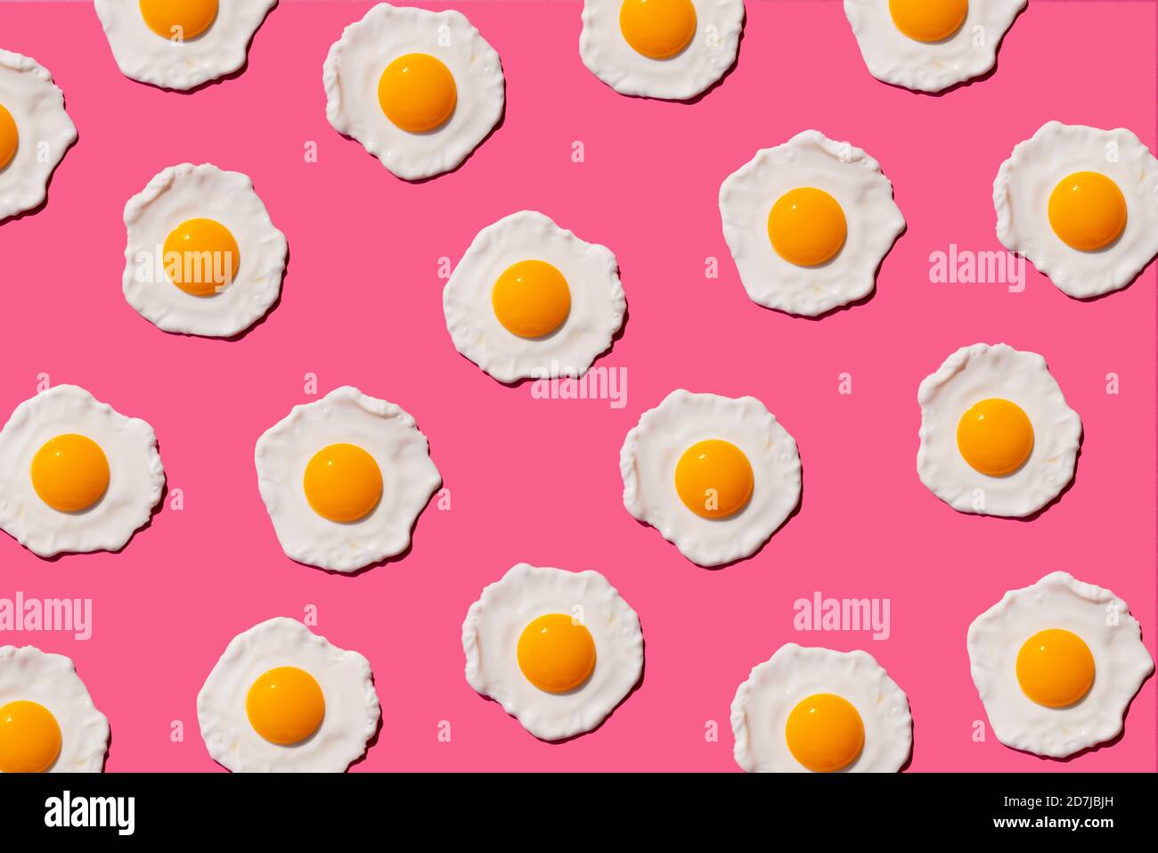 Pattern of fried eggs against pink background Stock Photo