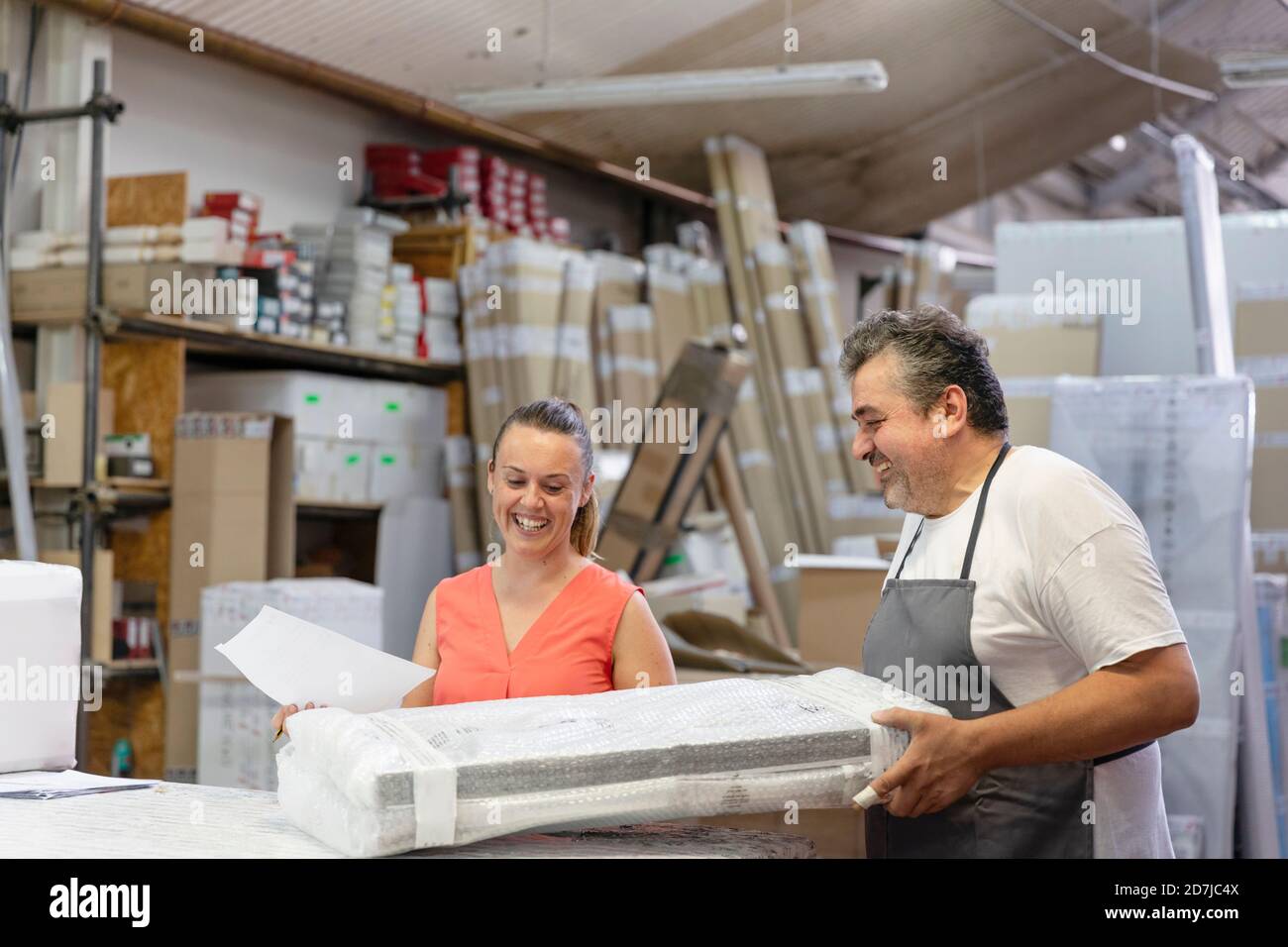 Smiling coworker and secretary working while standing at factory Stock Photo