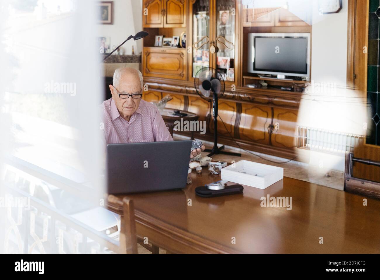 Elderly man using laptop at table Stock Photo