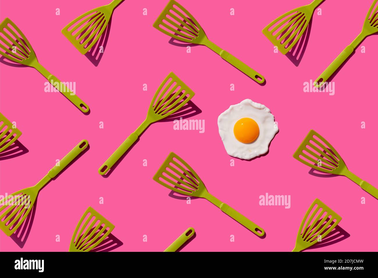 Pattern of green spatulas with single fried egg Stock Photo