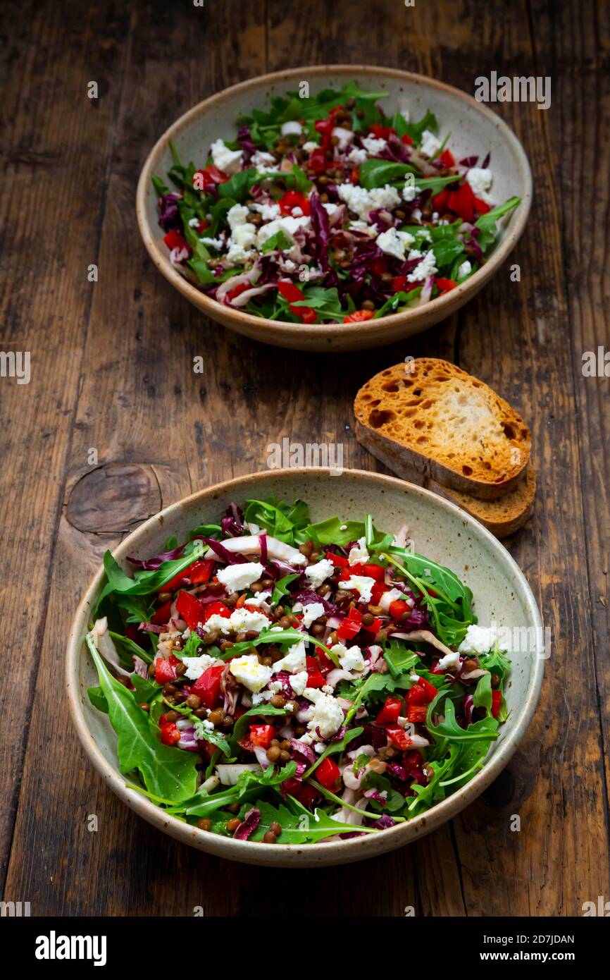 Two bowls of vegetable salad with lentils, arugula, red bell pepper, feta cheese and radicchio Stock Photo