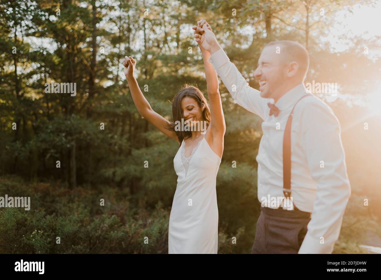 Happy couple dancing in forest during sunset Stock Photo - Alamy