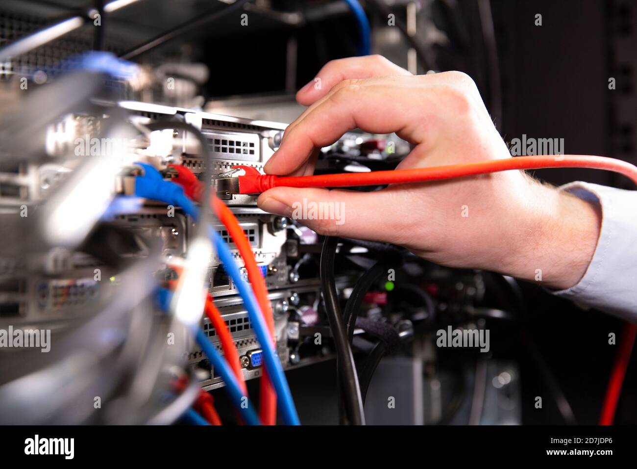 Close-up of male engineer examining network connection plug in data center Stock Photo