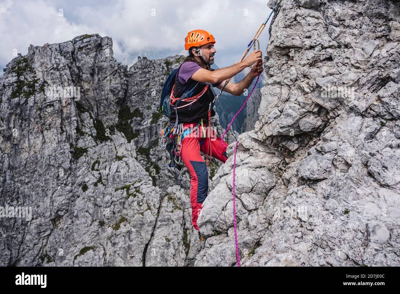 Male mountaineer with rope climbing on mountain, European Alps, Lecco, Italy Stock Photo