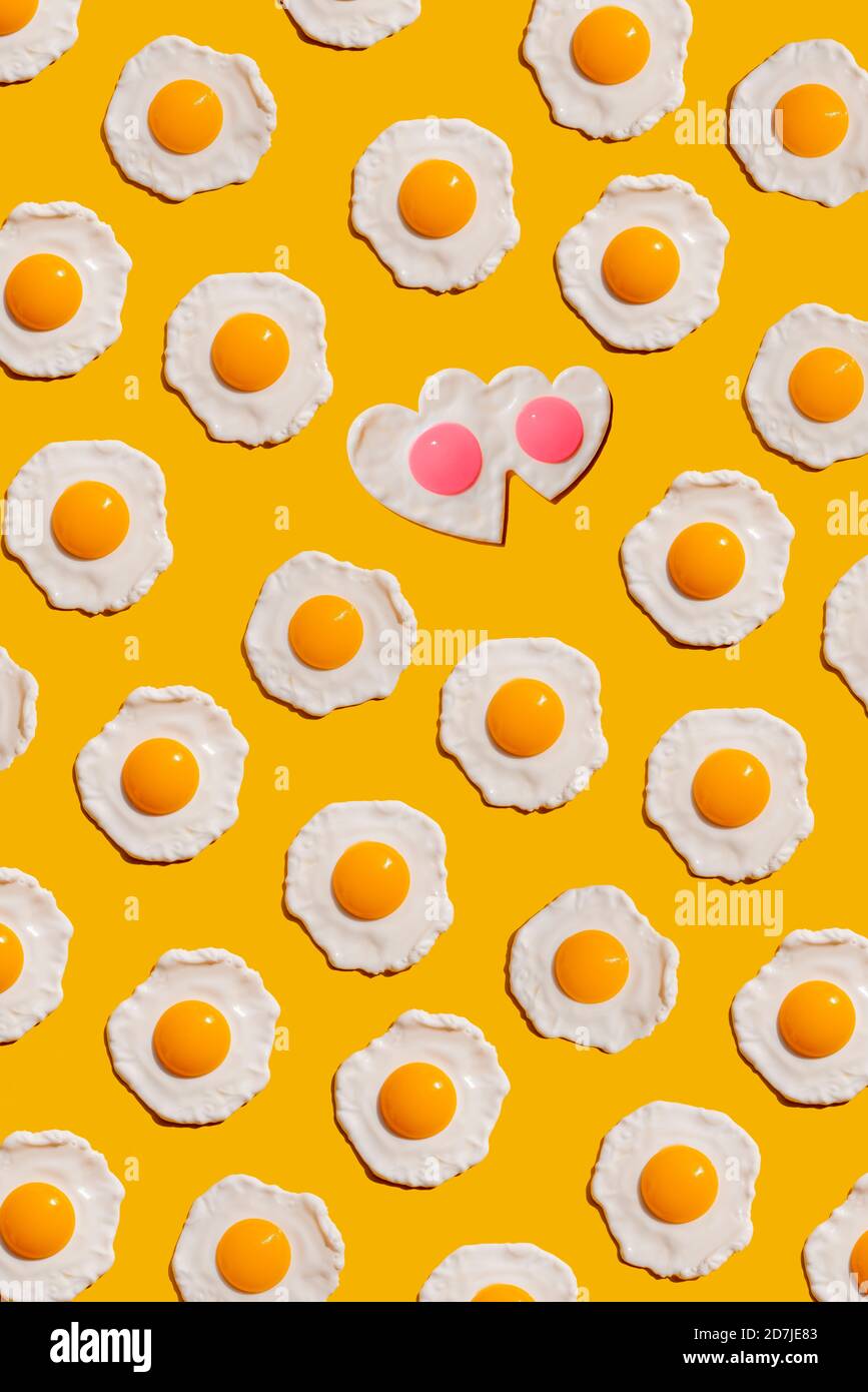 Pattern of fried eggs against yellow background Stock Photo
