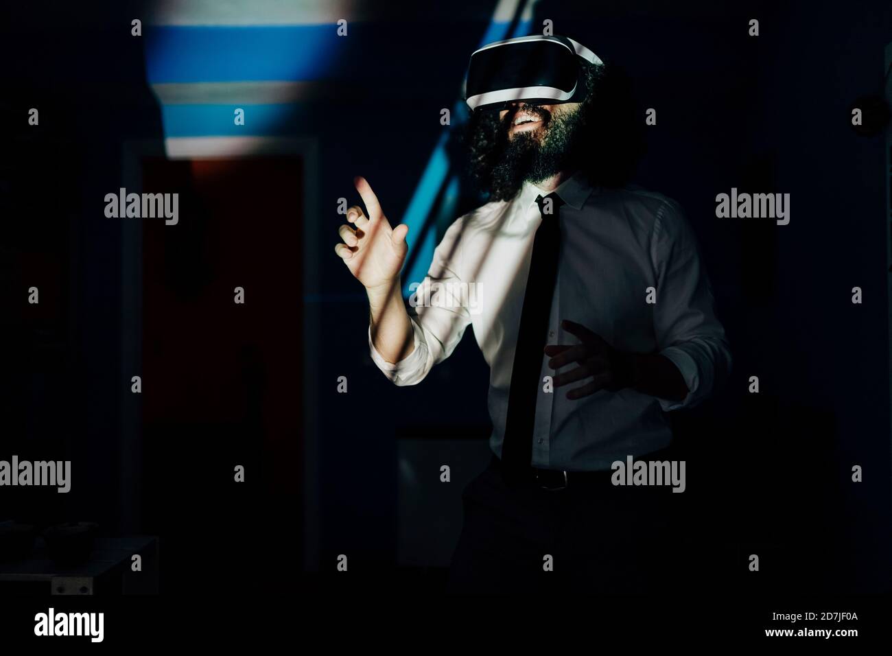 Man using virtual reality glasses while standing at home during pandemic Stock Photo