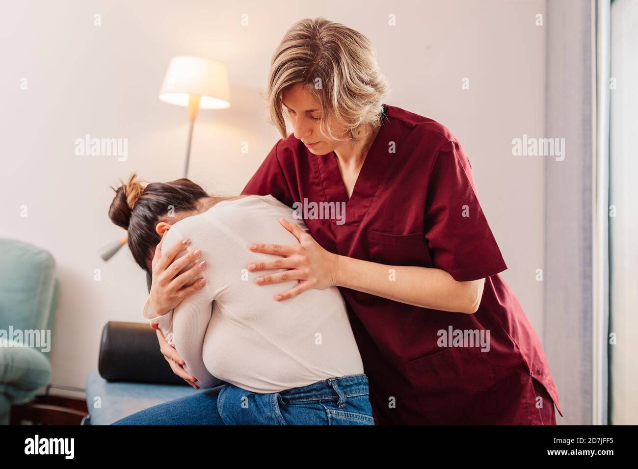 Physiotherapist helping woman for stretching Stock Photo