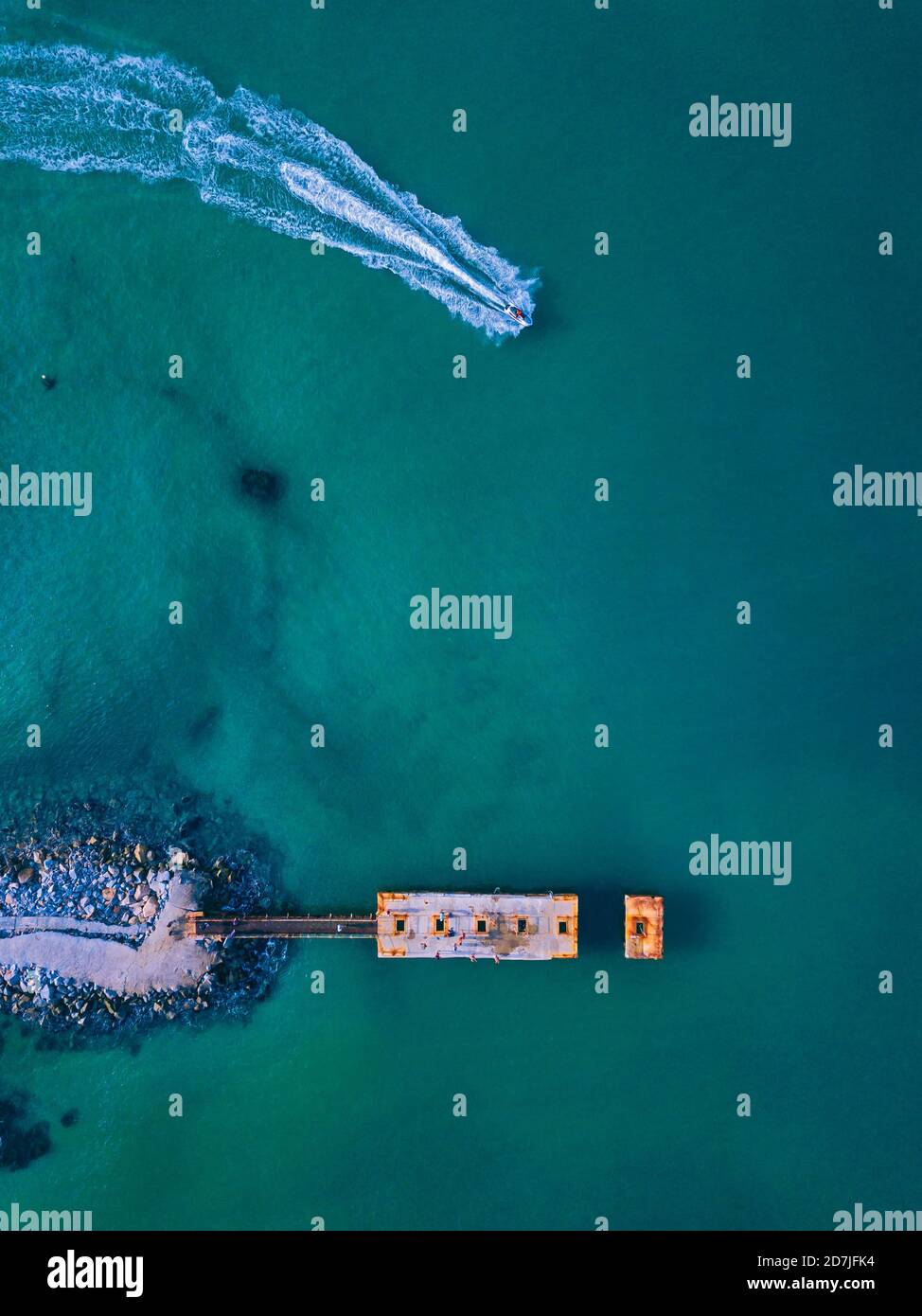 Aerial view of small pier and jet boat sailing in turquoise water Stock ...