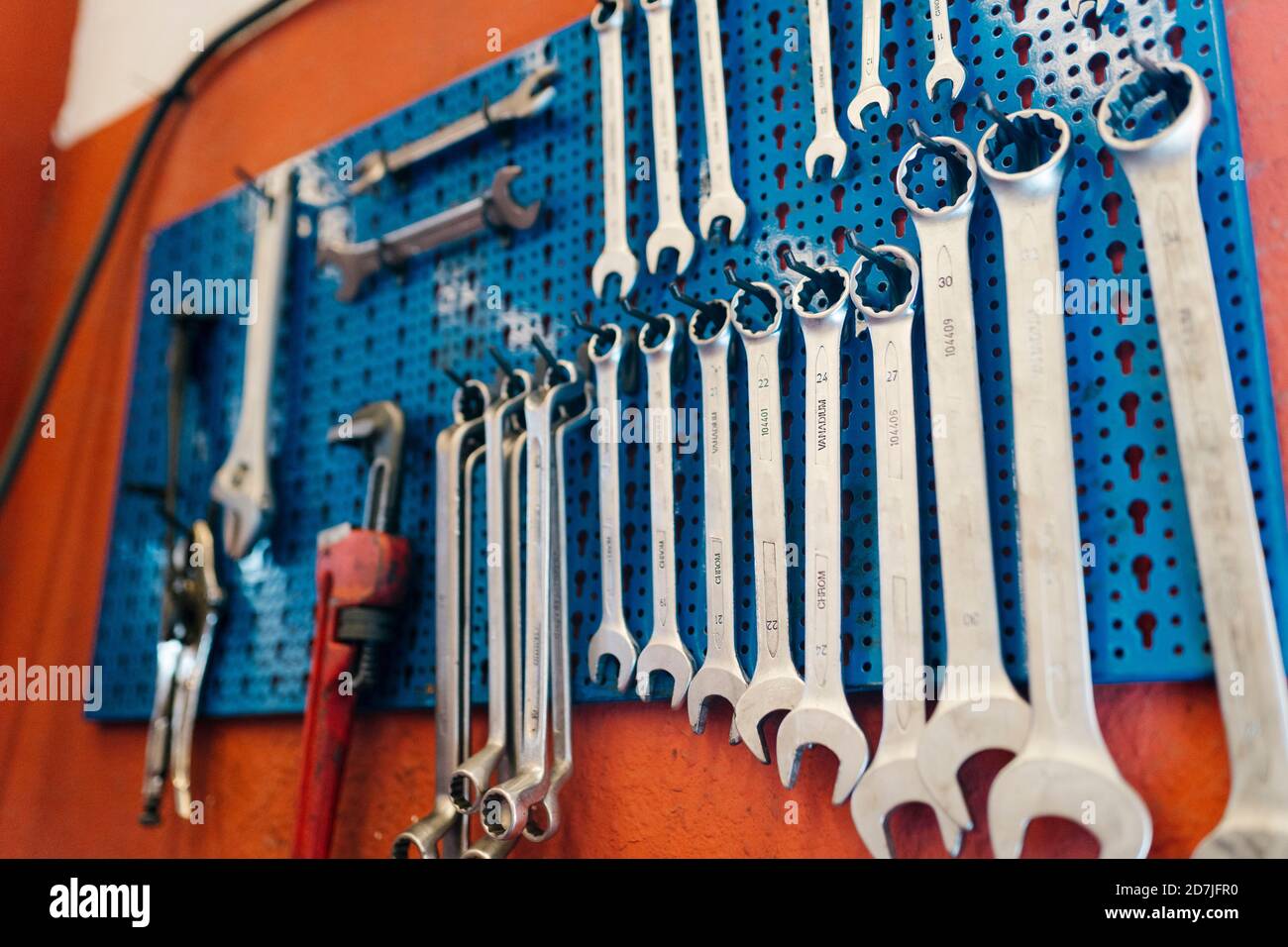 Close-up of work tools hanging on pegboard in workshop Stock Photo
