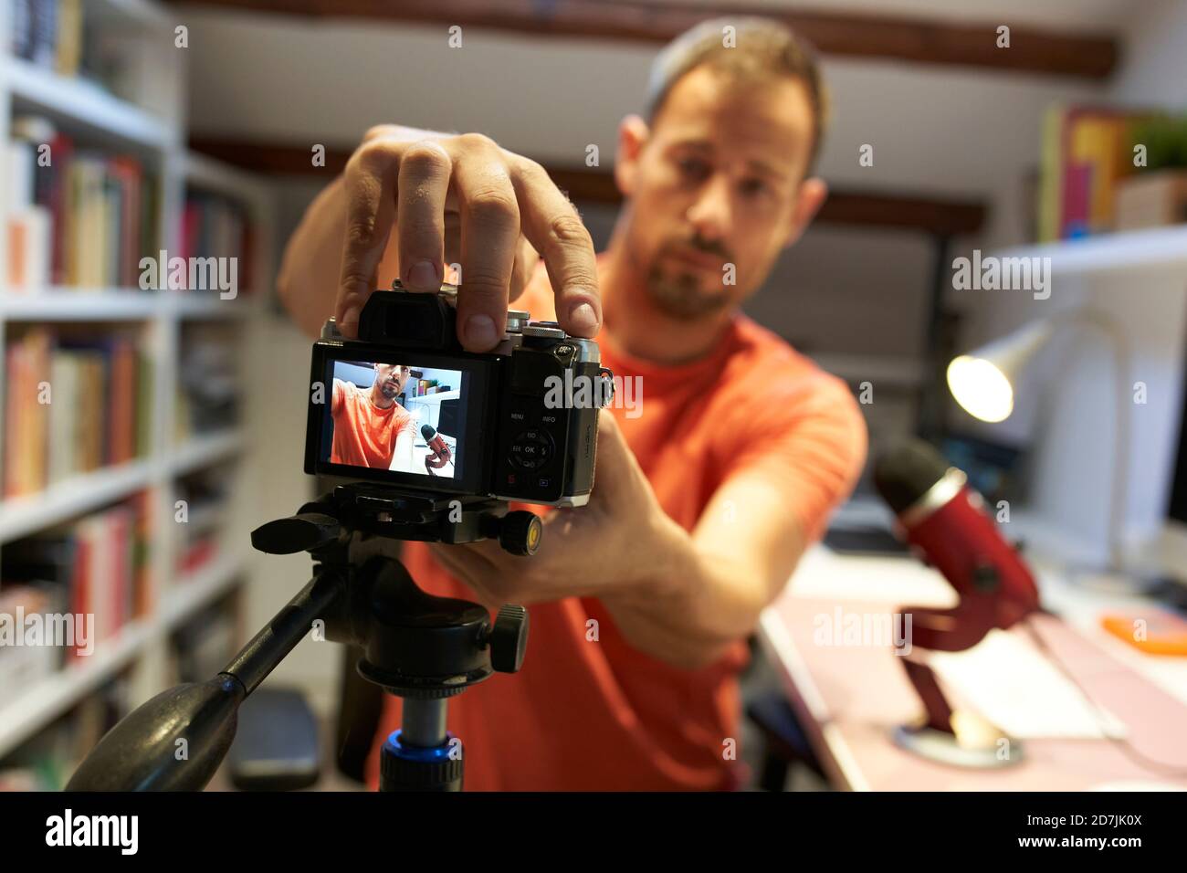 Mid adult man adjusting camera for recording video tutorial Stock Photo