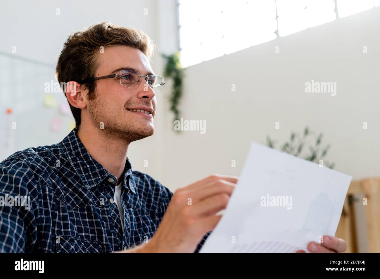Young man smiling while working at office Stock Photo