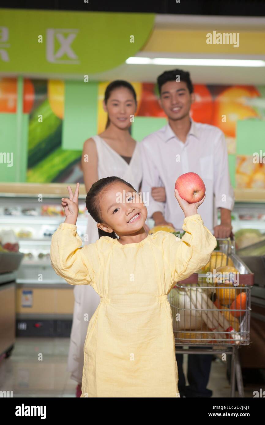 A happy family of three in the supermarket shopping Stock Photo