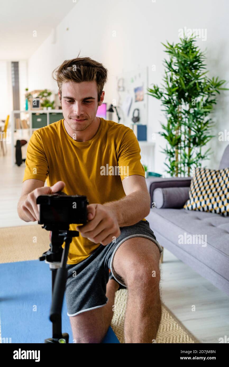 Fitness trainer adjusting camera for live streaming at home Stock Photo