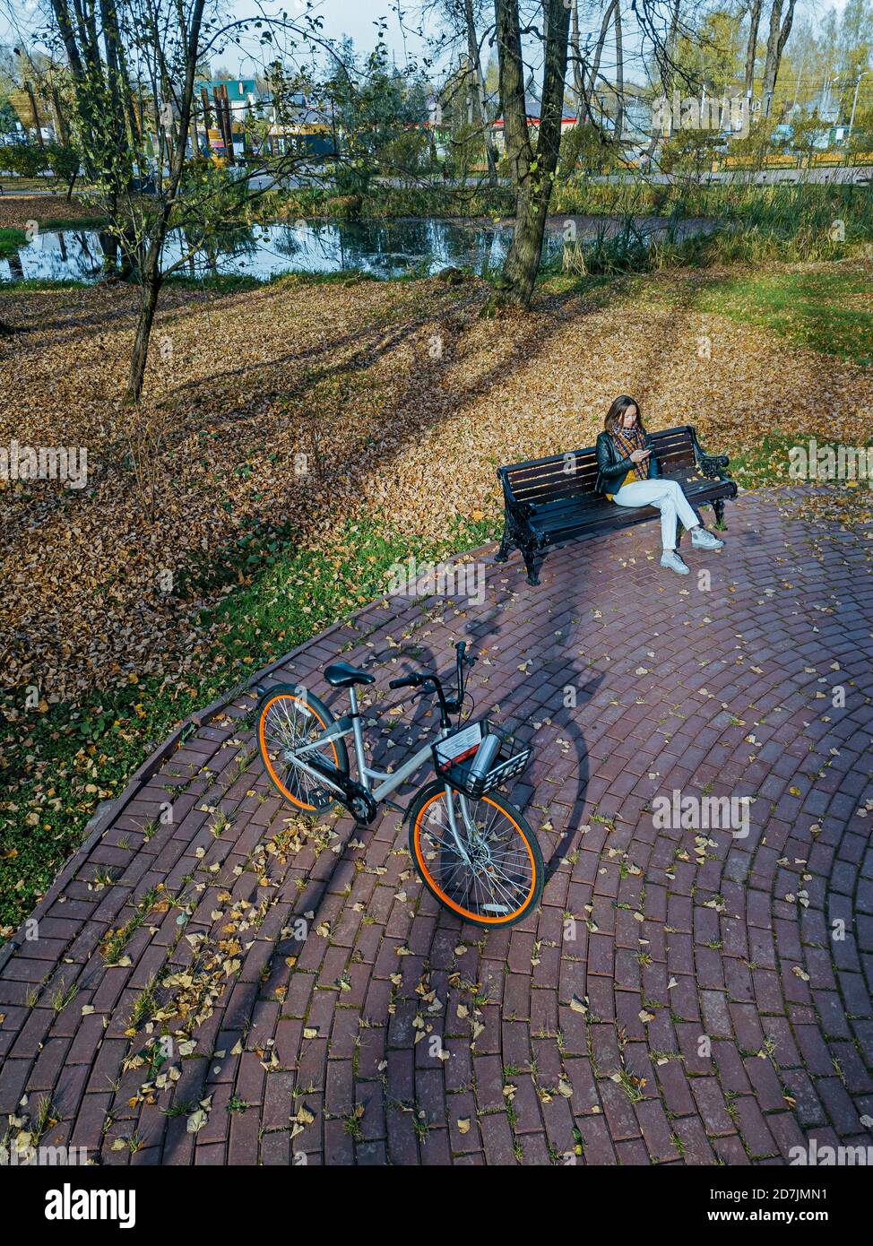 Young woman sitting alone on park bench hires stock photography and