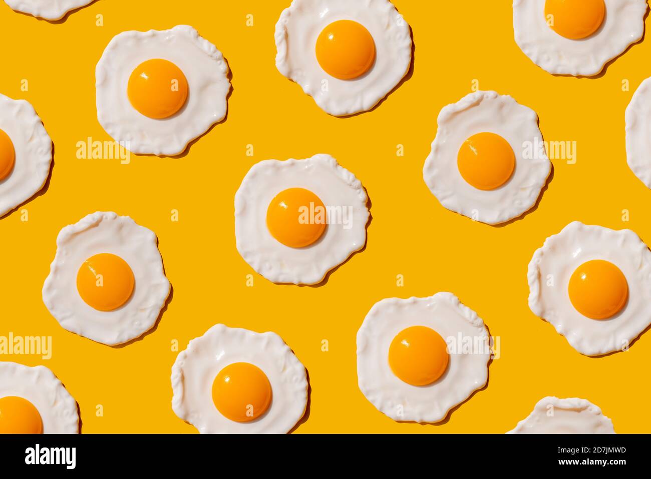 Pattern of fried eggs against yellow background Stock Photo