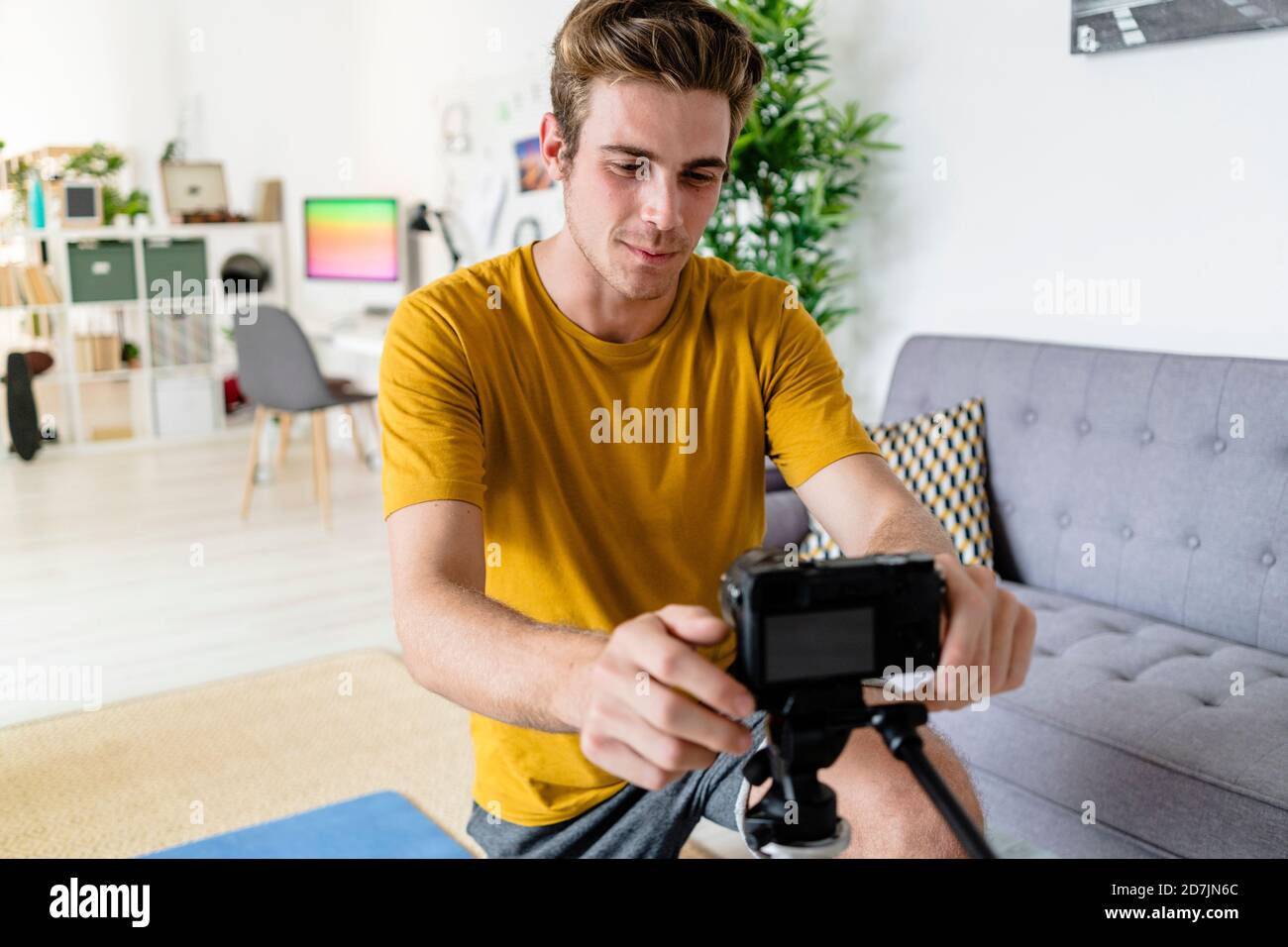Trainer adjusting camera for live streaming at home Stock Photo