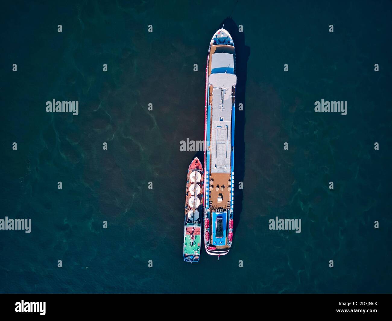 Barge refueling recreational boat on Volga River Stock Photo
