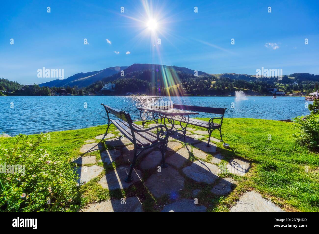 Table and bench by lake against mountain at Turracher Hoehe, Gurktal Alps, Austria Stock Photo