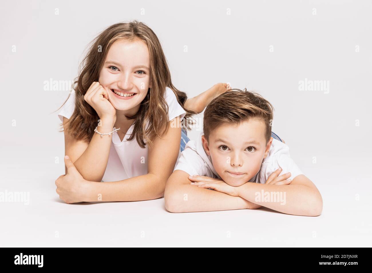 Cute siblings lying on white background Stock Photo