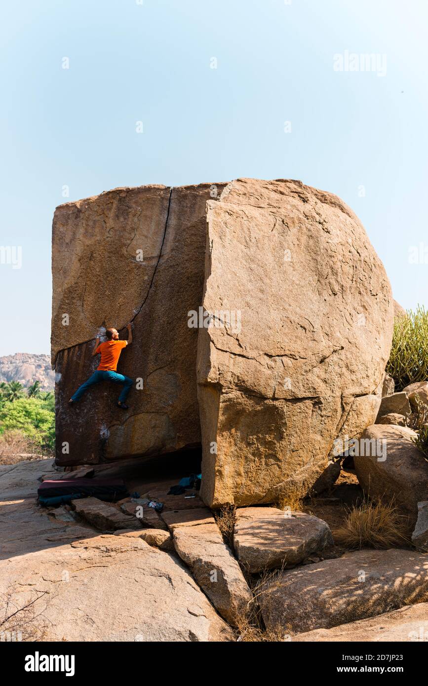 Male rock climber ascending huge boulder Stock Photo