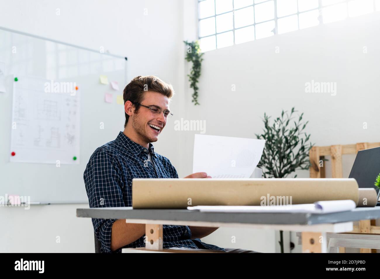 Smiling man working while sitting by desk at office Stock Photo