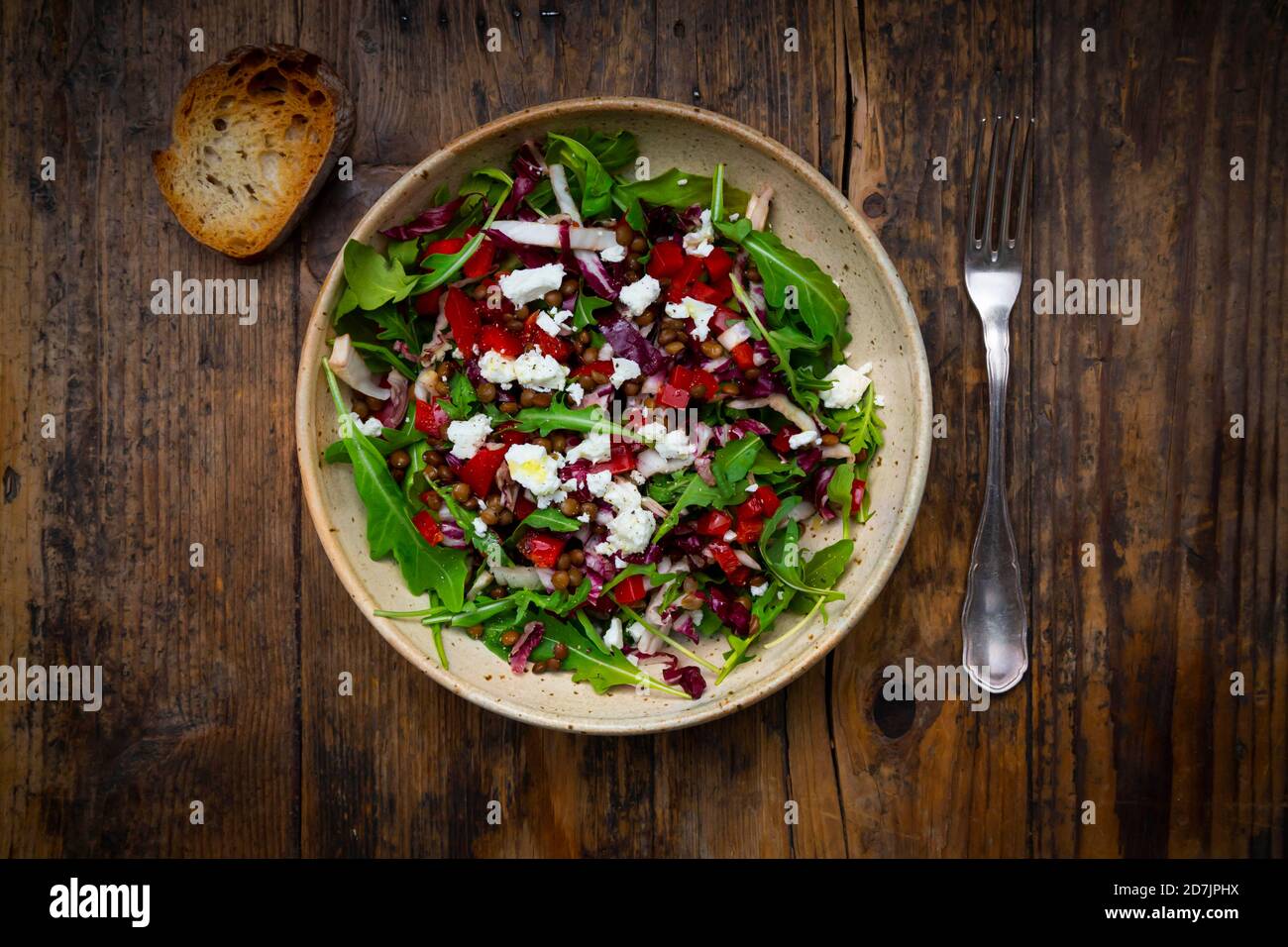 Bowl of vegetable salad with lentils, arugula, red bell pepper, feta cheese and radicchio Stock Photo