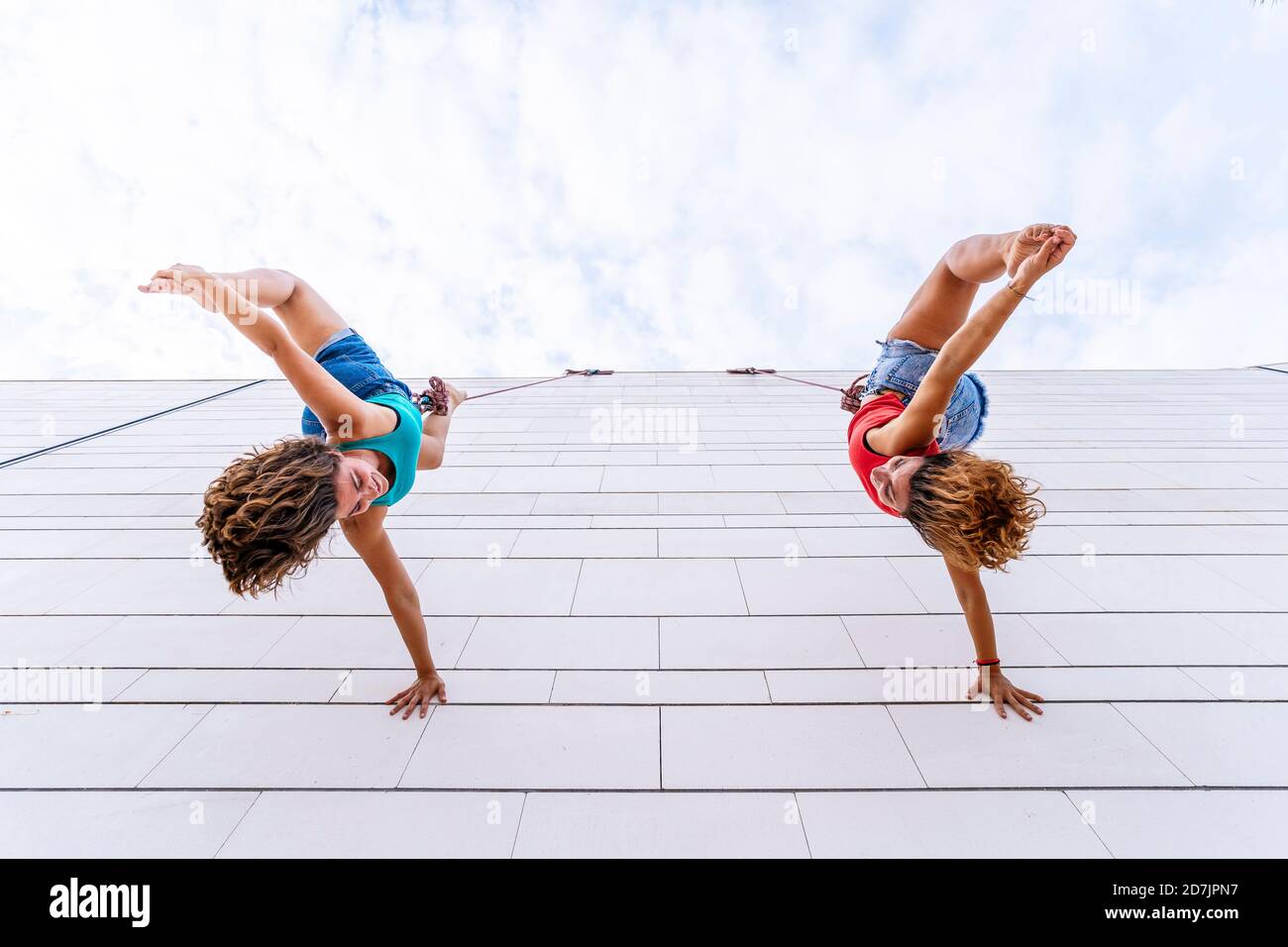 Aerial dancers touching toes while hanging on window Stock Photo