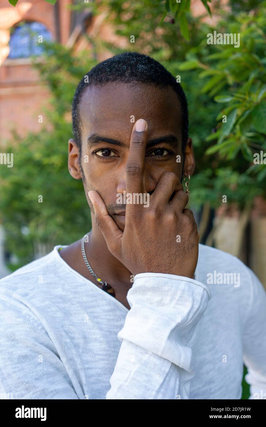 Man covering with face with hand while standing at public park Stock Photo