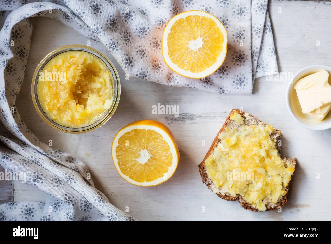 Orange slice and homemade jam kept with bread and butter on table Stock Photo
