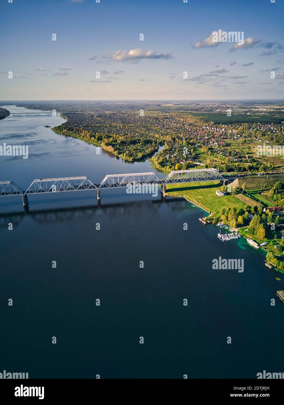 Railway bridge over Volga River in city against sky at sunset seen from above Stock Photo